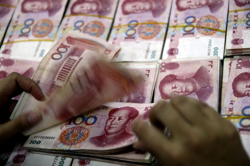 A Chinese bank staff counts stacks of 100-yuan notes in Huaibei, east China's Anhui province on October 20, 2010.